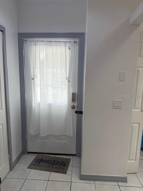 An interior entryway features a white door with a sheer curtain and a welcome mat — 9943 BURL WAY, ORLANDO, FL