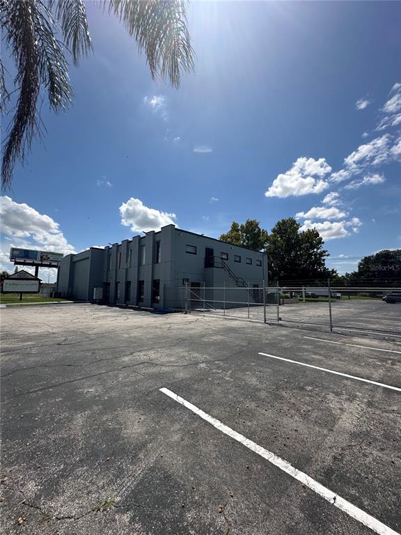 An exterior view of a gray, two-story commercial building with a paved parking lot — 2300 S ORANGE BLOSSOM TRAIL, ORLANDO, FL
