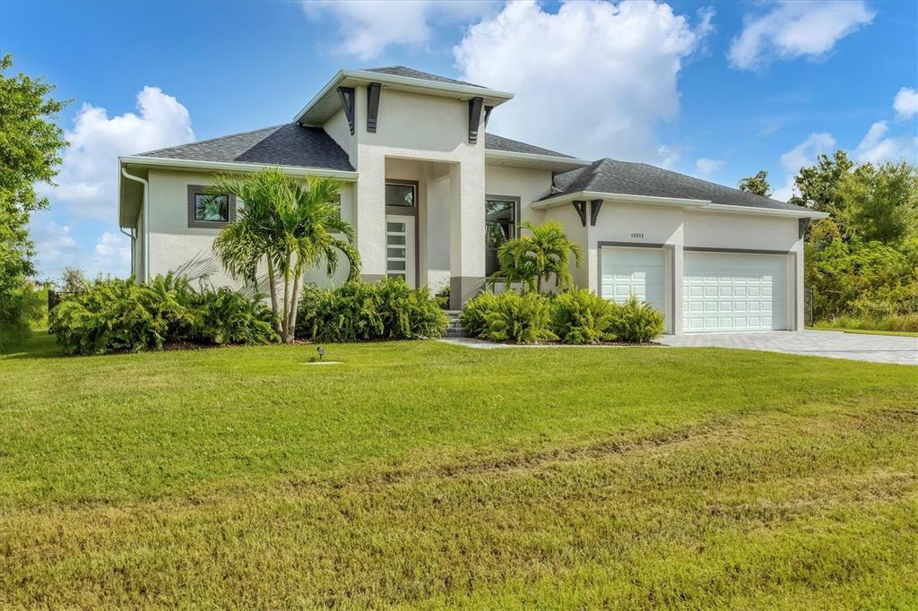 A single-story house with a white stucco exterior, a dark shingled roof, and a two-car garage — 0 SYMCO AVENUE, NORTH PORT, FL