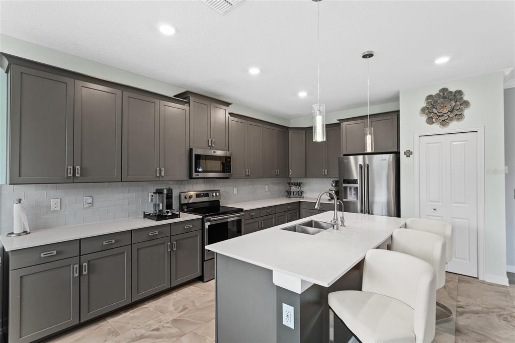 A kitchen with grey cabinets, white countertops, stainless steel appliances, and a central island — 2215 CAMDEN PARK AVENUE, DAVENPORT, FL