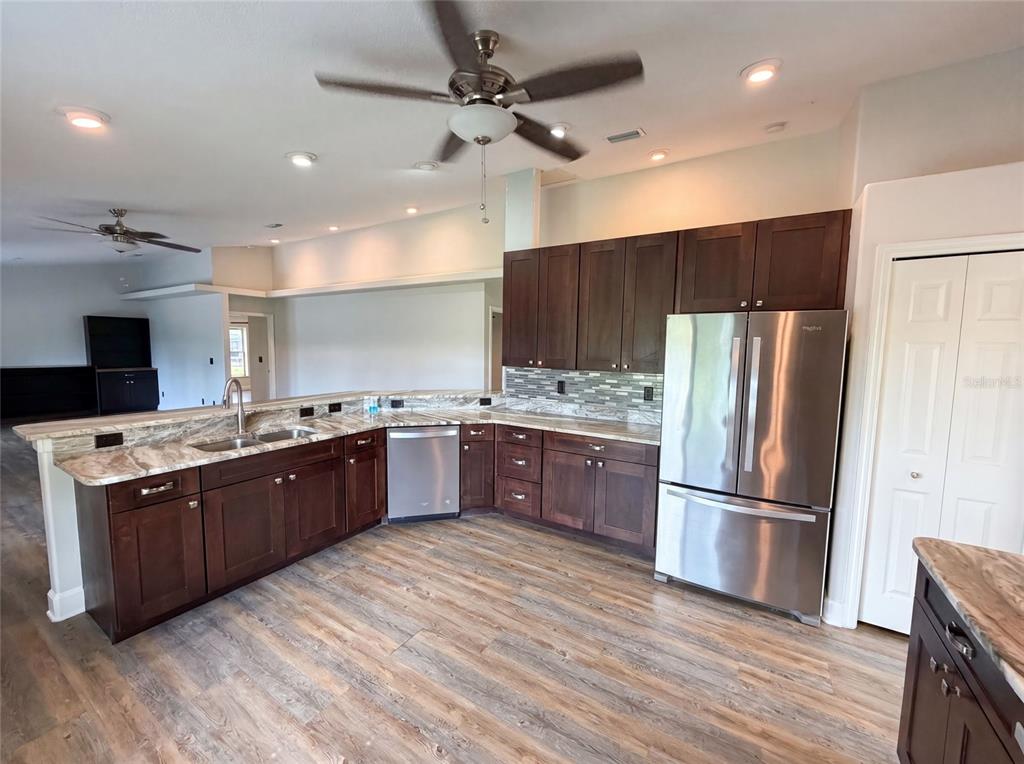 A kitchen with dark wood cabinets, stainless steel appliances, and granite countertops — 2620 KELLY LANE, MALABAR, FL