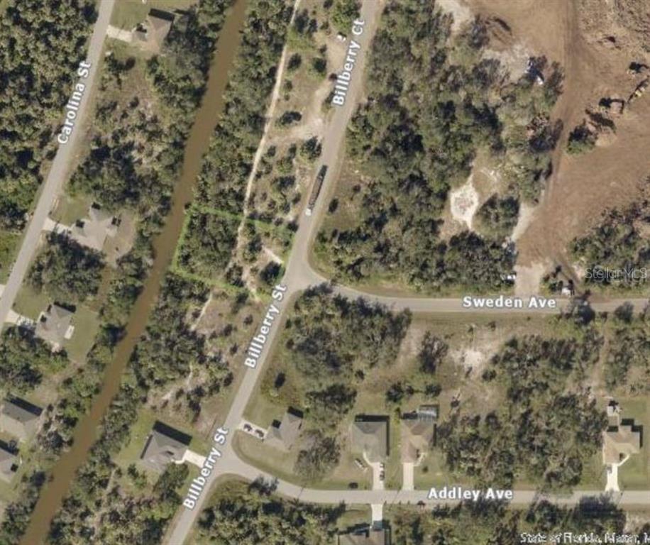 This aerial map shows a vacant, wooded residential lot located at a street intersection — BILLBERRY STREET, NORTH PORT, FL