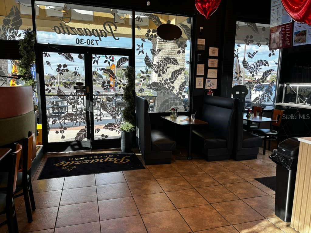 The interior of a coffee shop features black booths, tiled floors, and glass entry doors — 730 SAND LAKE ROAD UNIT 30, ORLANDO, FL
