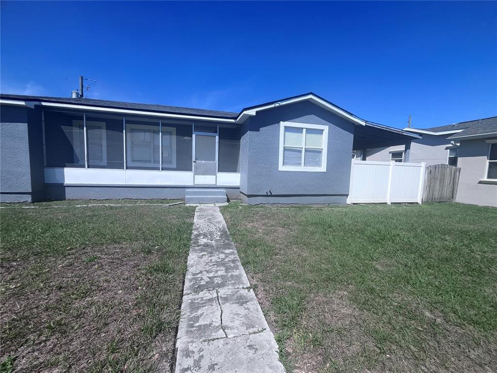A single-story gray house with a screened-in porch and a concrete walkway — 3215 W PINE STREET, TAMPA, FL