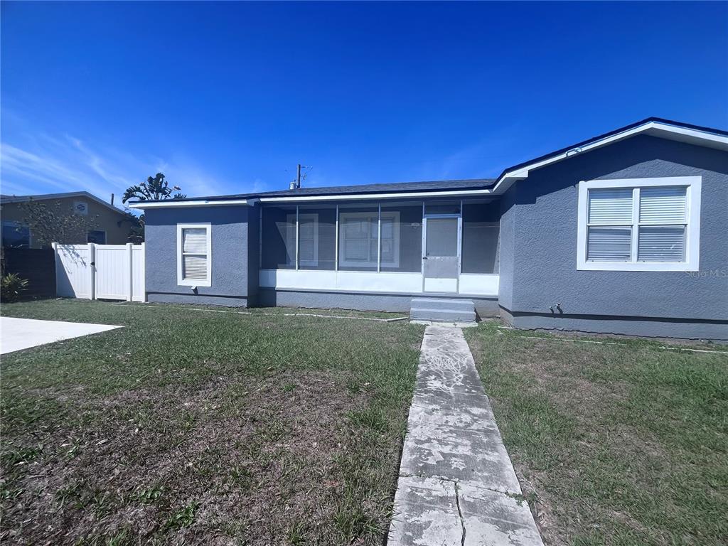 A gray house with a screened-in front porch and a concrete walkway leading to the entrance — 3215 W PINE STREET, TAMPA, FL