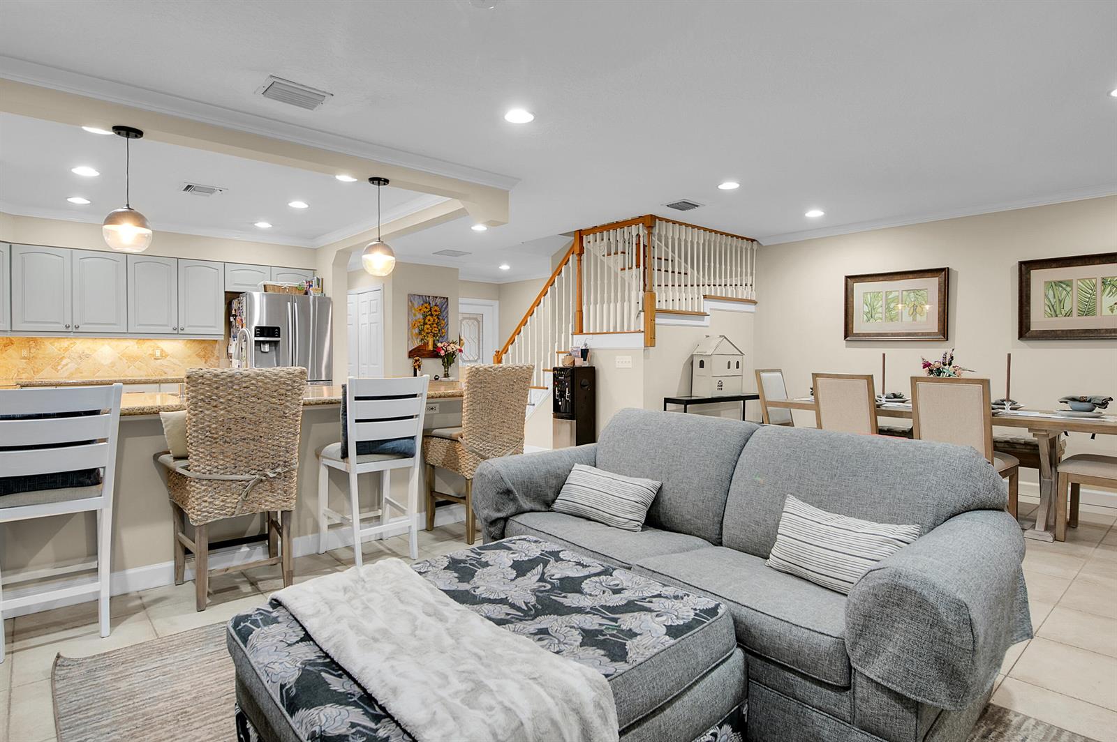 An open-concept living room, dining area, and kitchen with a breakfast bar and staircase — 22860 Ironwedge Drive, Boca Raton FL 33433, BOCA RATON, FL