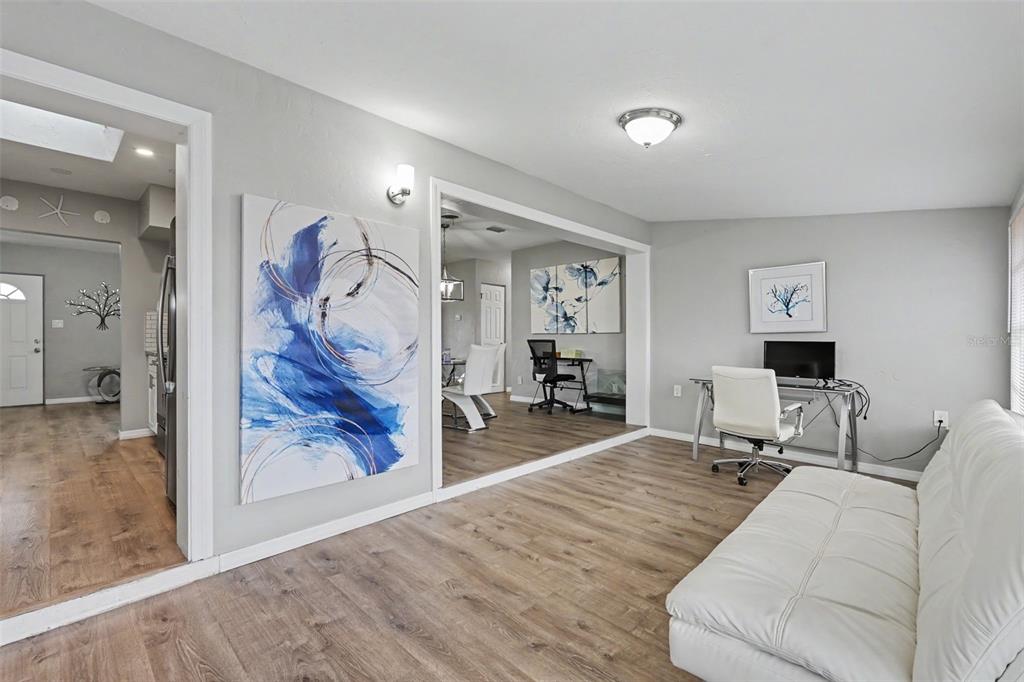 A living room features light gray walls, wood-look flooring, a white sofa, and a desk — 316 GLEN OAK ROAD, VENICE, FL