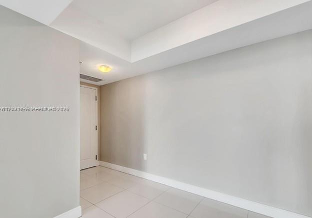 A hallway with light-colored tile flooring, white walls, and a closed white door — 1871 NW S River Dr # 1606, Miami FL 33125, MIAMI, FL