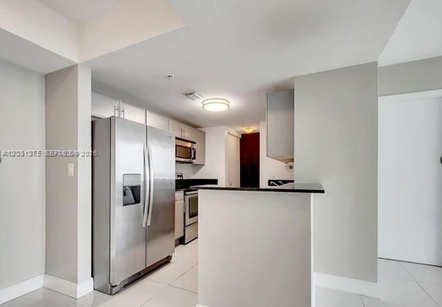 A modern kitchen features stainless steel appliances, light-colored cabinetry, and a breakfast bar — 1871 NW S River Dr # 1606, Miami FL 33125, MIAMI, FL