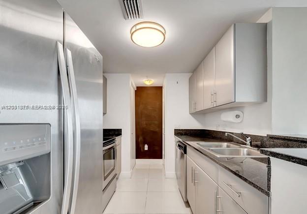 A kitchen features stainless steel appliances, white cabinetry, and dark granite countertops — 1871 NW S River Dr # 1606, Miami FL 33125, MIAMI, FL