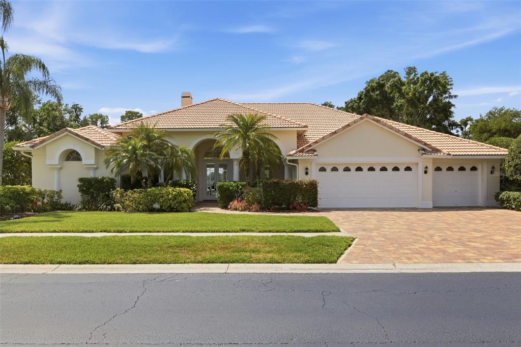 A single-story house with a tile roof, three-car garage, and a paved driveway — 3626 SWANS LANDING DRIVE, LAND O LAKES, FL