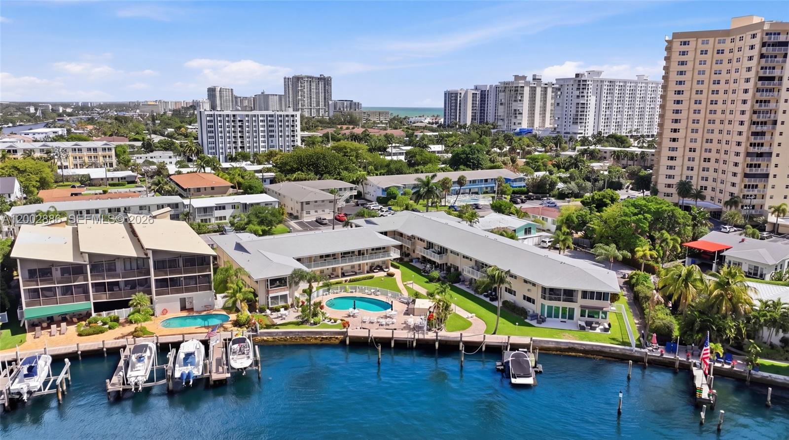 An aerial view shows waterfront apartment buildings with swimming pools and private boat docks — 3216 SE 12th St # 8, Pompano Beach FL 33062, POMPANO BEACH, FL