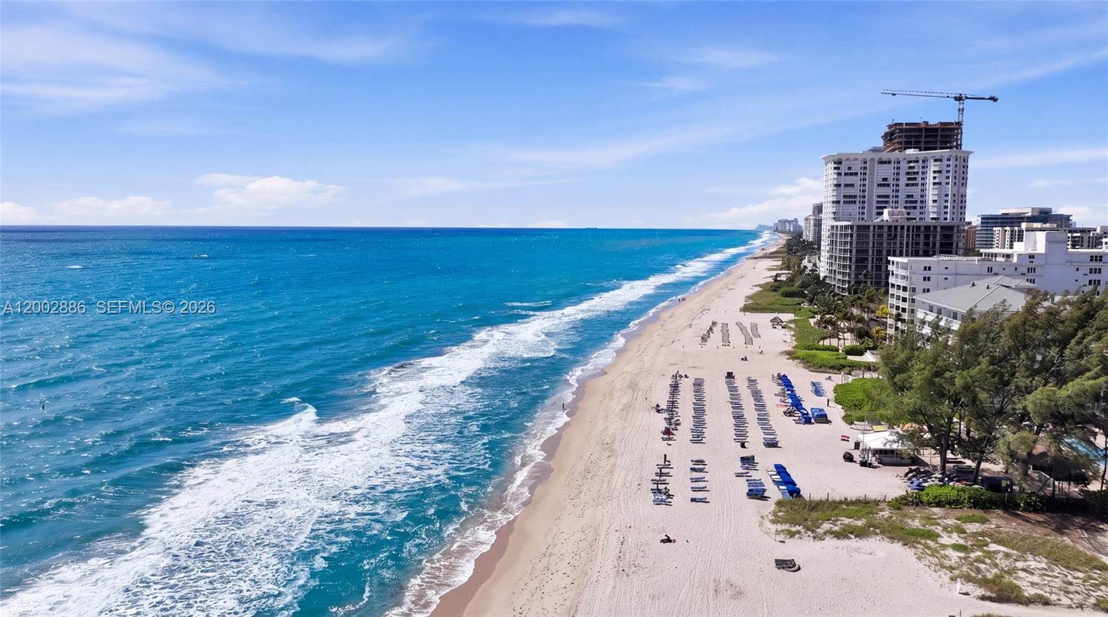 An aerial view of a sandy beach with lounge chairs and high-rise buildings — 3216 SE 12th St # 8, Pompano Beach FL 33062, POMPANO BEACH, FL