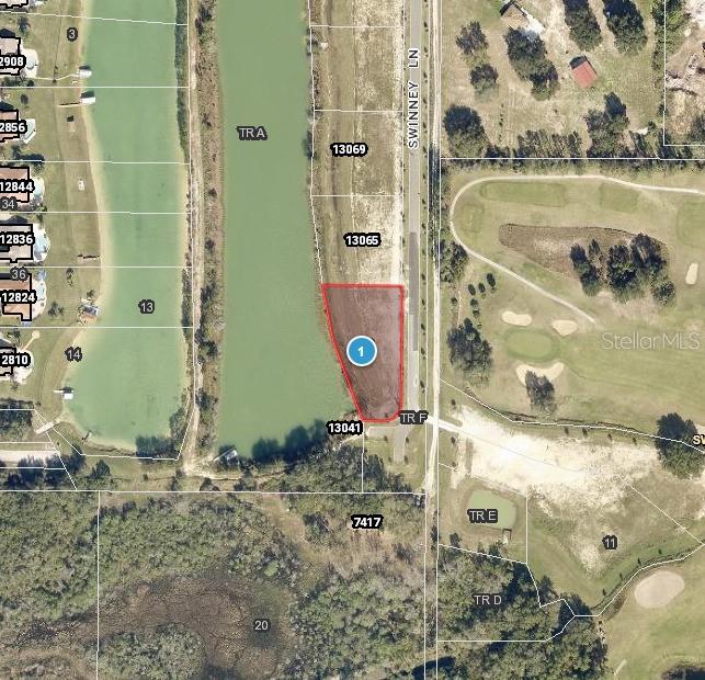 This is an aerial map showing a vacant lot highlighted in red along a lake — 13061 SWINNEY LANE, CLERMONT, FL