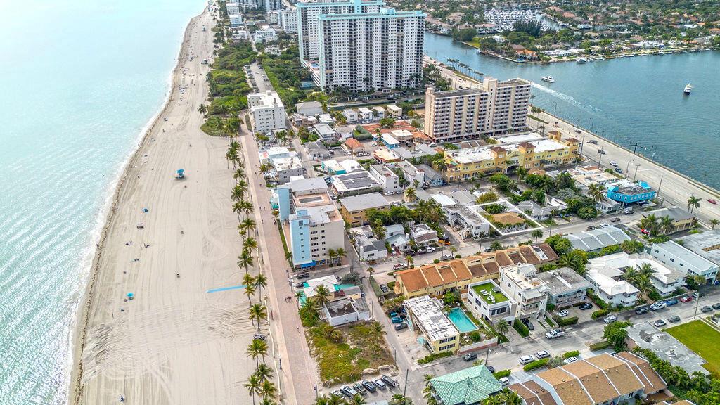 An aerial view shows a sandy beach, coastal buildings, and a waterway with boats — 334 Oregon Street, Hollywood FL 33019, HOLLYWOOD, FL