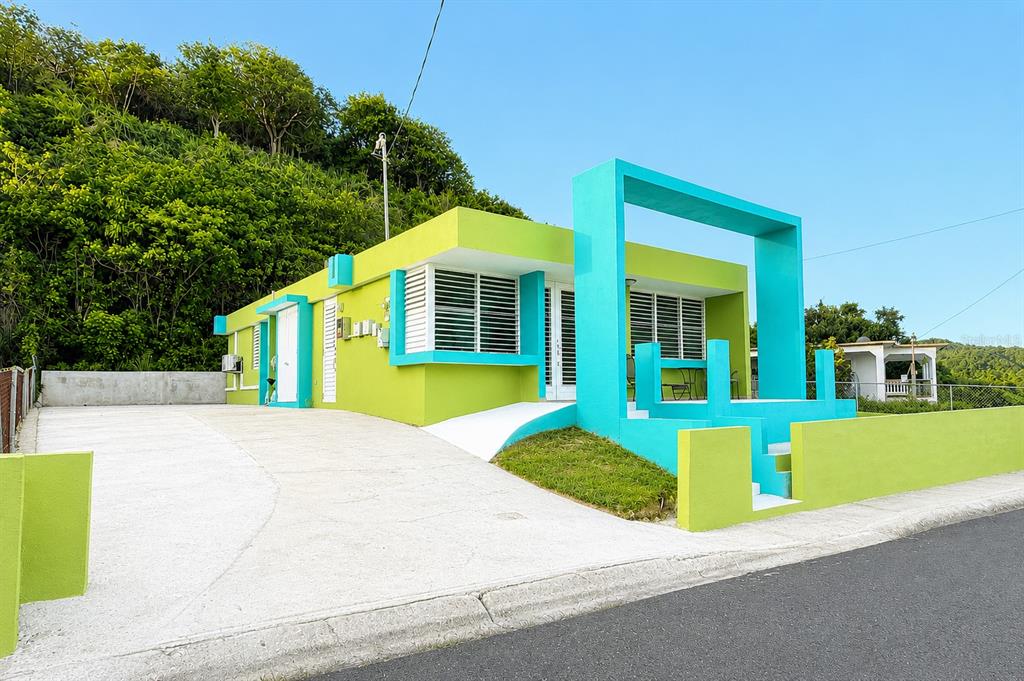 A bright lime green and turquoise house with a concrete driveway and a grassy yard — 471 CALLE 22 BO. MARIANI, MAUNABO, PR