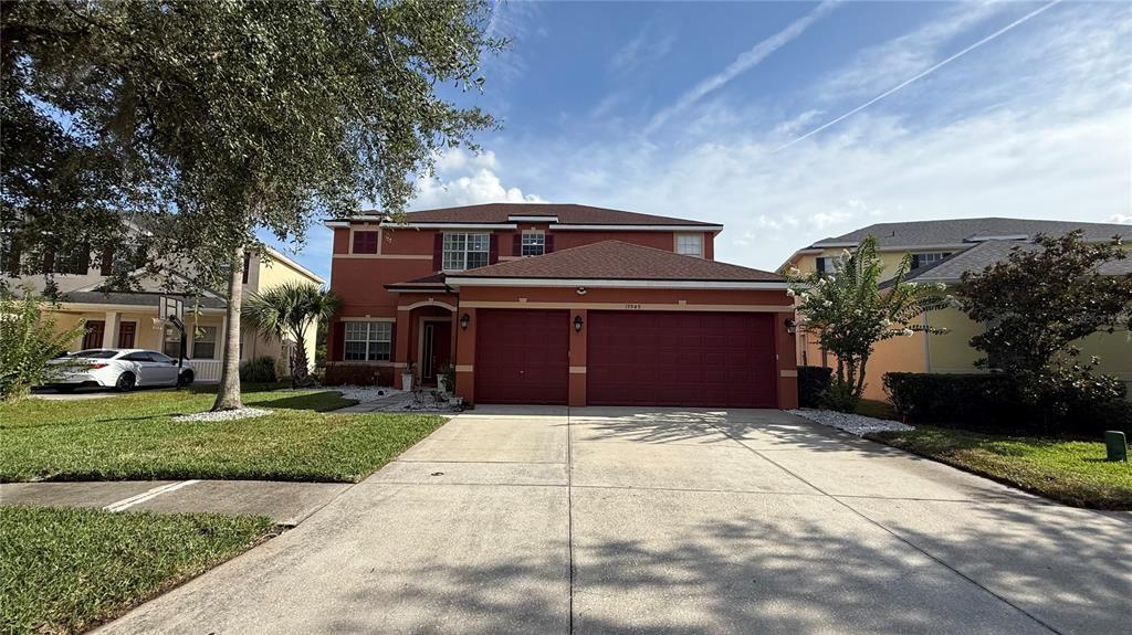 A two-story house with a red exterior, a two-car garage, and a concrete driveway — 19949 TAMIAMI AVENUE, TAMPA, FL
