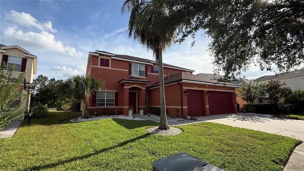 A two-story, orange-stucco house with a two-car garage and a front lawn — 19949 TAMIAMI AVENUE, TAMPA, FL