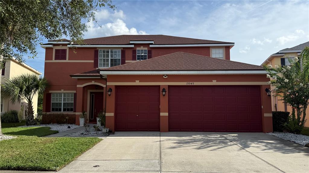 A two-story house with a terracotta exterior, a three-car garage, and a shingled roof — 19949 TAMIAMI AVENUE, TAMPA, FL