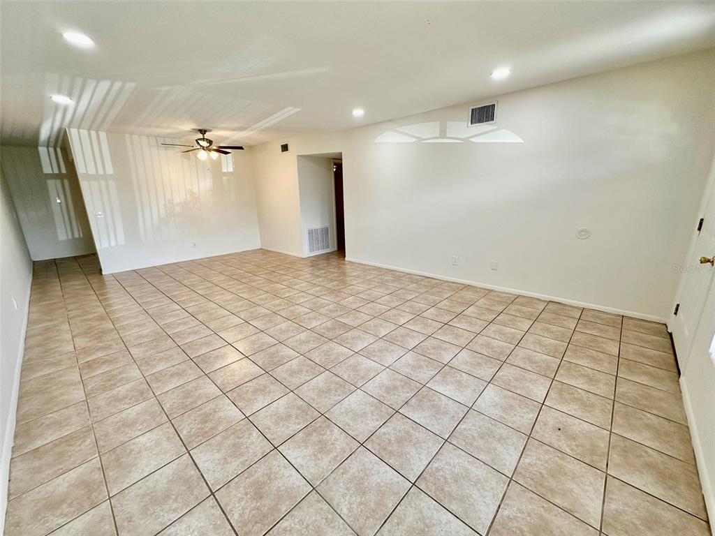 An empty room with beige tile flooring, white walls, and a ceiling fan — 2073 DENMARK STREET UNIT 5, CLEARWATER, FL
