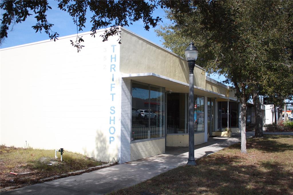 A single-story commercial building with a light-colored facade and large display windows — 710 N MAIN STREET, GAINESVILLE, FL