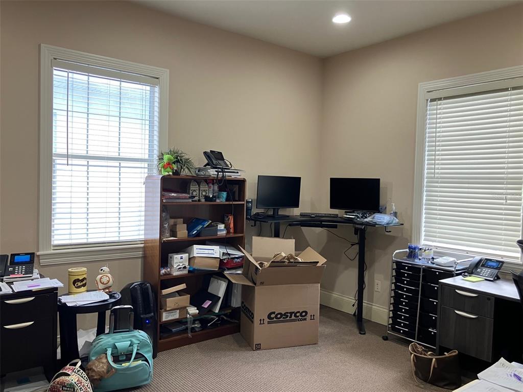 A home office features two windows, a standing desk with monitors, a bookshelf, and storage cabinets — 5813 and 5815 S MACDILL AVENUE, TAMPA, FL