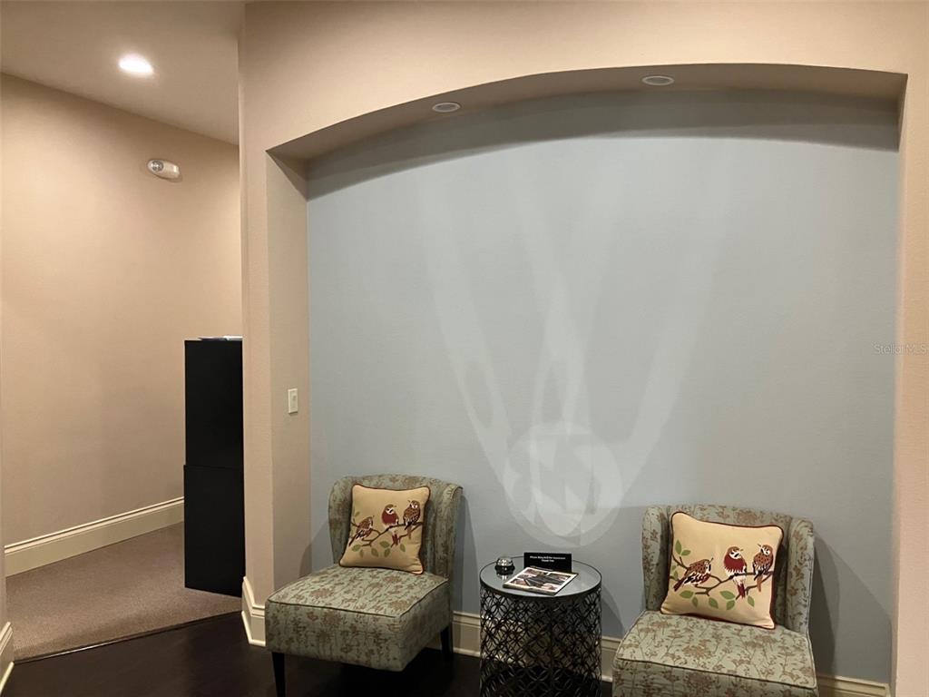 Two patterned chairs sit before a light blue arched wall niche with a small table — 5813 and 5815 S MACDILL AVENUE, TAMPA, FL