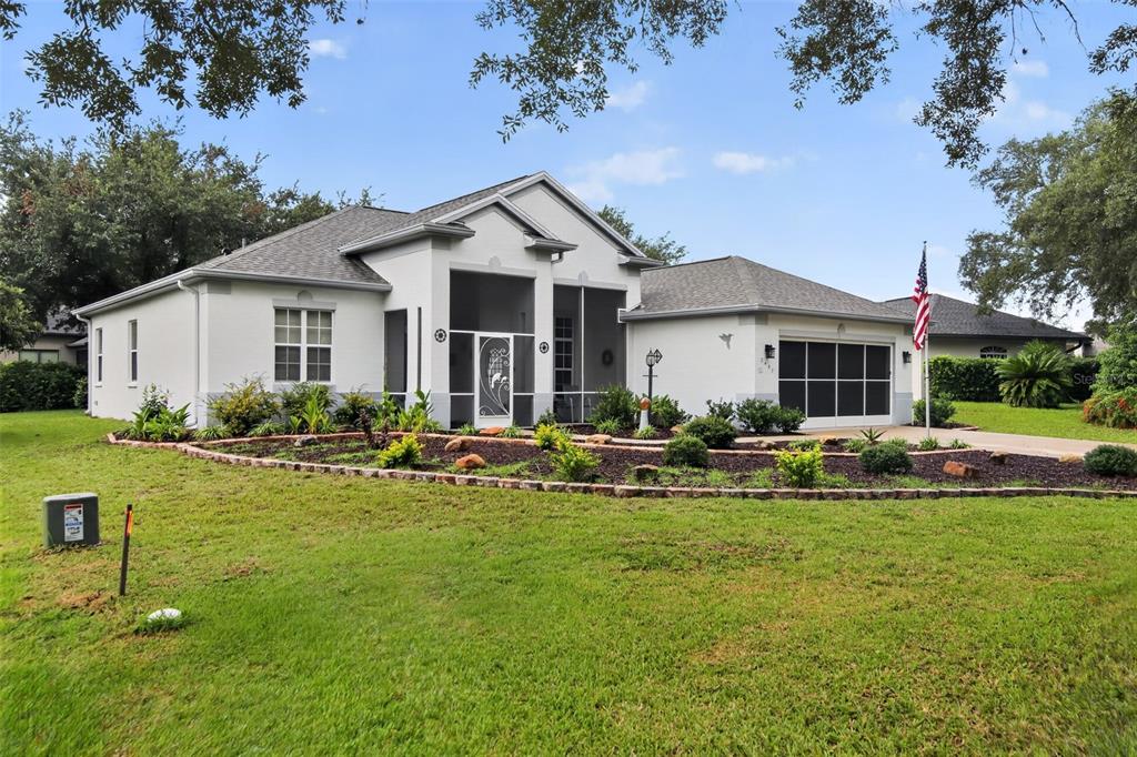 A single-story house with a screened front porch, a two-car garage, and a landscaped yard — 2457 N BRENTWOOD CIRCLE, LECANTO, FL