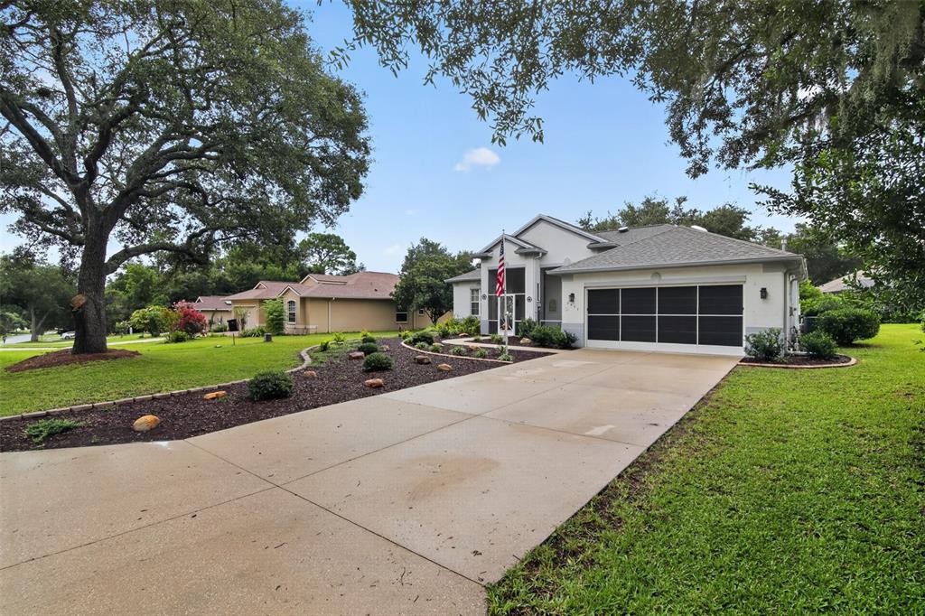 A single-story house with a concrete driveway, a two-car garage, and a landscaped front yard — 2457 N BRENTWOOD CIRCLE, LECANTO, FL