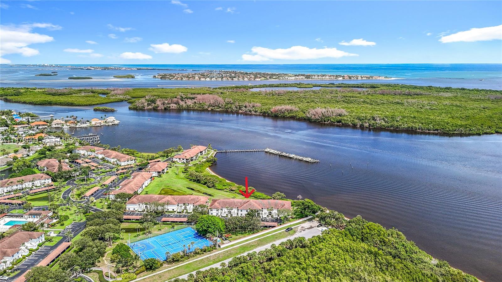 An aerial view shows a multi-story residential building with a red arrow pointing toward it — 6082 SE Landing Way # 11, Stuart FL 34997, STUART, FL