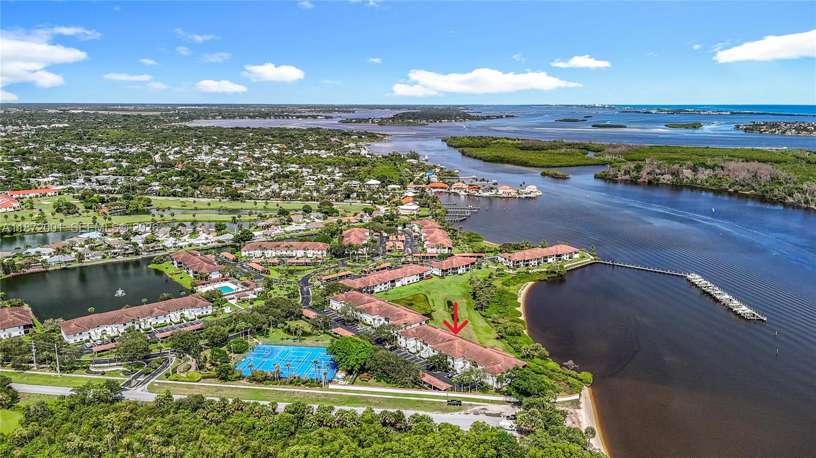 An aerial view shows a multi-story residential complex with a tennis court near a waterway — 6082 SE Landing Way # 11, Stuart FL 34997, STUART, FL