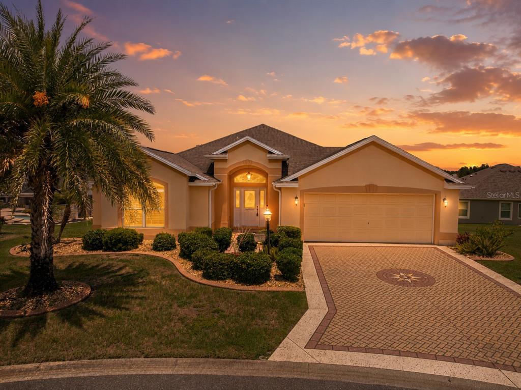 A single-story house with a paved driveway and palm tree at sunset — 2875 ADRIENNE WAY, THE VILLAGES, FL