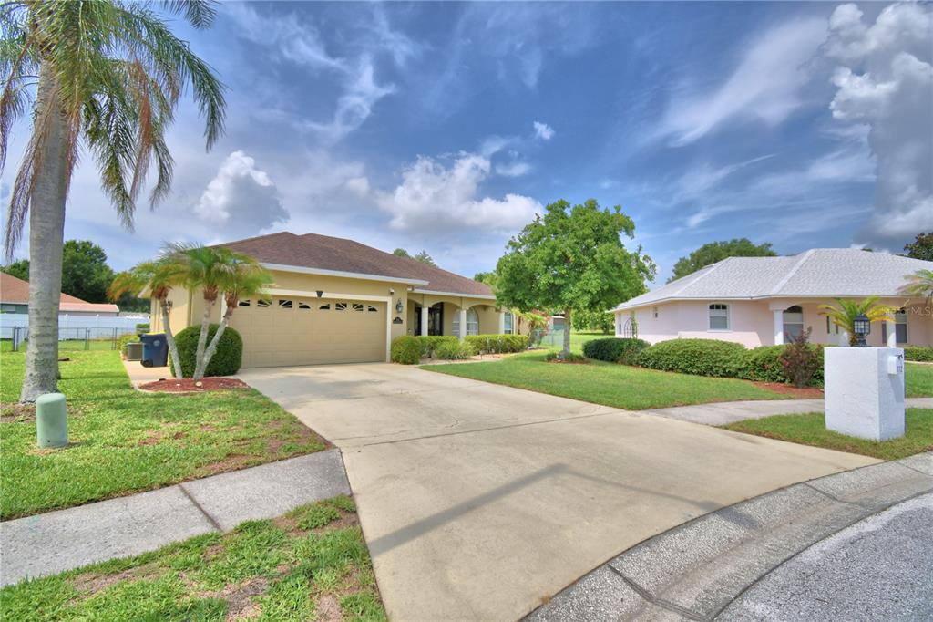 A beige single-story house with a two-car garage and a concrete driveway — 112 WATERVIEW CIRCLE, AUBURNDALE, FL