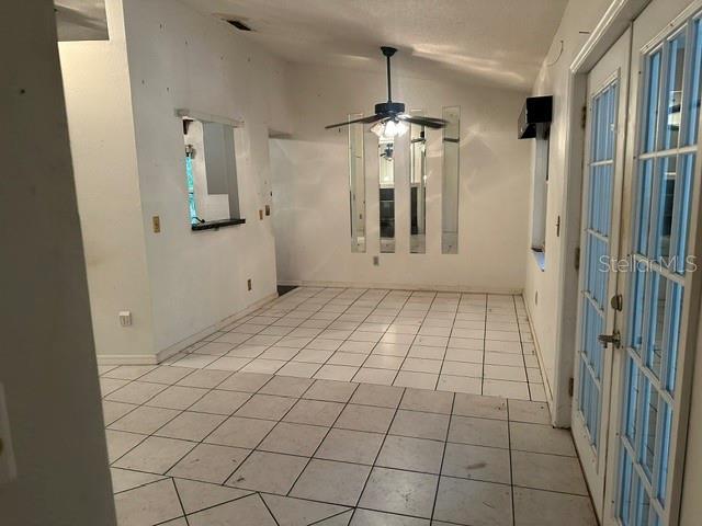 A dining area with white tiled floors, a ceiling fan, and vertical wall mirrors — 4729 S DAWNMEADOW COURT, PLANT CITY, FL
