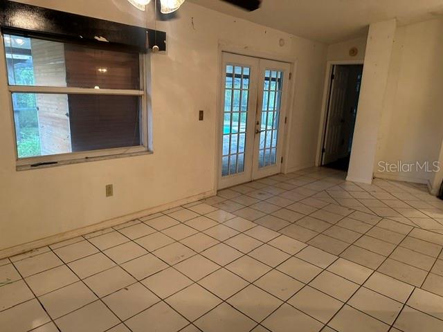 A room with white tiled floors, a large window, and glass doors leading outside — 4729 S DAWNMEADOW COURT, PLANT CITY, FL
