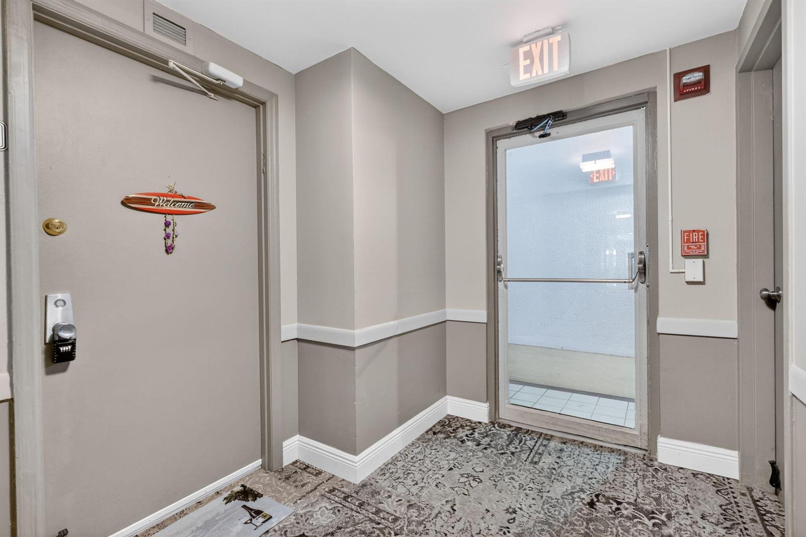 An interior hallway features a gray door with a welcome sign and a glass exit door — 1200 Marine Way, North Palm Beach FL 33408, NORTH PALM BEACH, FL
