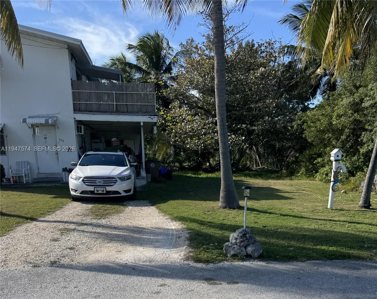 A two-story house sits on a grassy lot with palm trees and parked cars — 329 63rd Court Gulf, Marathon FL 33050, MARATHON, FL
