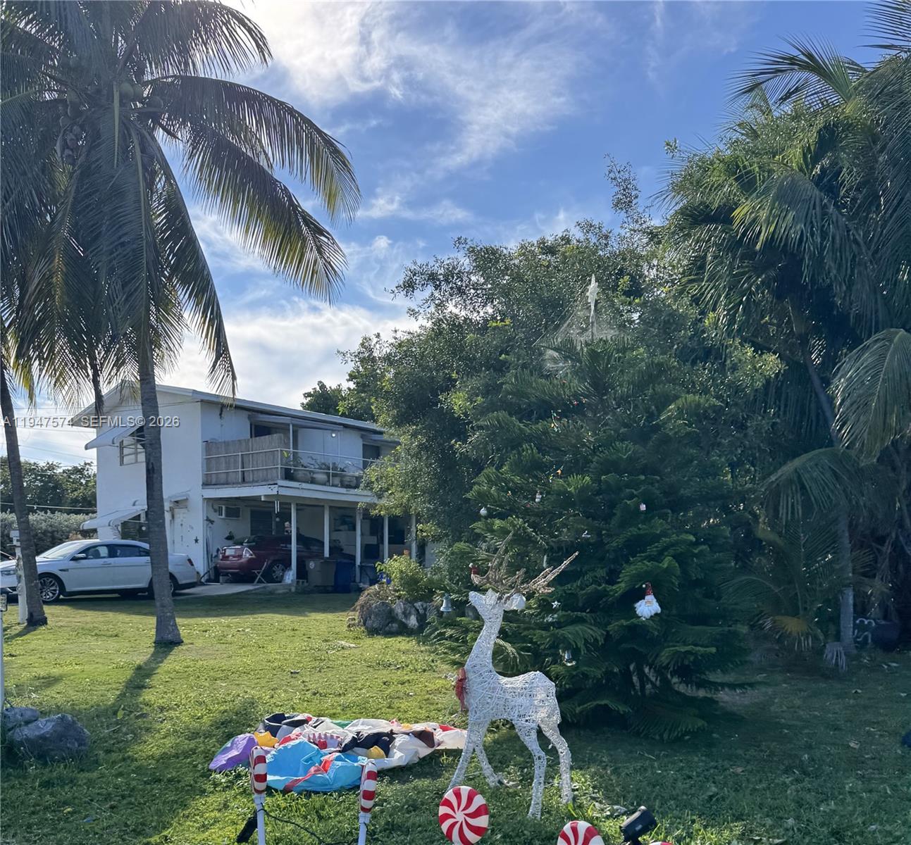 A two-story white house with an exterior staircase sits on a grassy lot — 329 63rd Court Gulf, Marathon FL 33050, MARATHON, FL