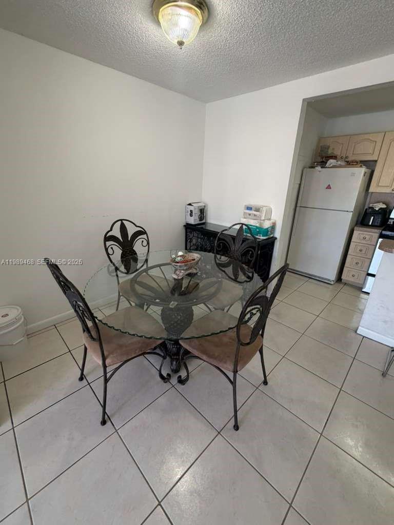 A dining area features a glass-topped table with four chairs and tiled flooring — 4154 NW 79th Ave # 2A, Doral FL 33166, DORAL, FL