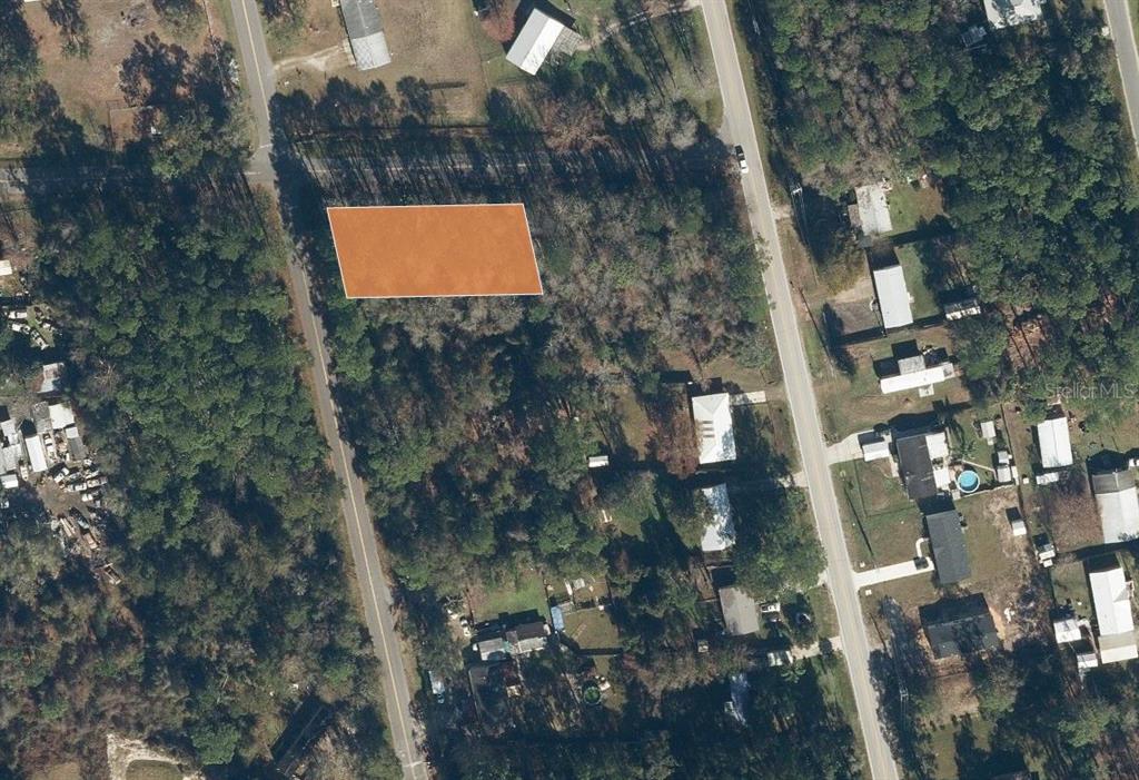 This aerial view shows a rectangular, highlighted plot of land surrounded by trees and roads — 110 PAMELA DRIVE, SATSUMA, FL