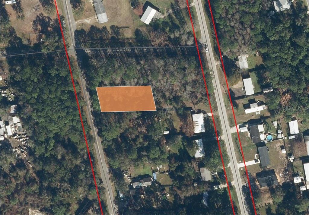 An aerial view shows a rectangular, highlighted plot of land situated between two roads — 110 PAMELA DRIVE, SATSUMA, FL