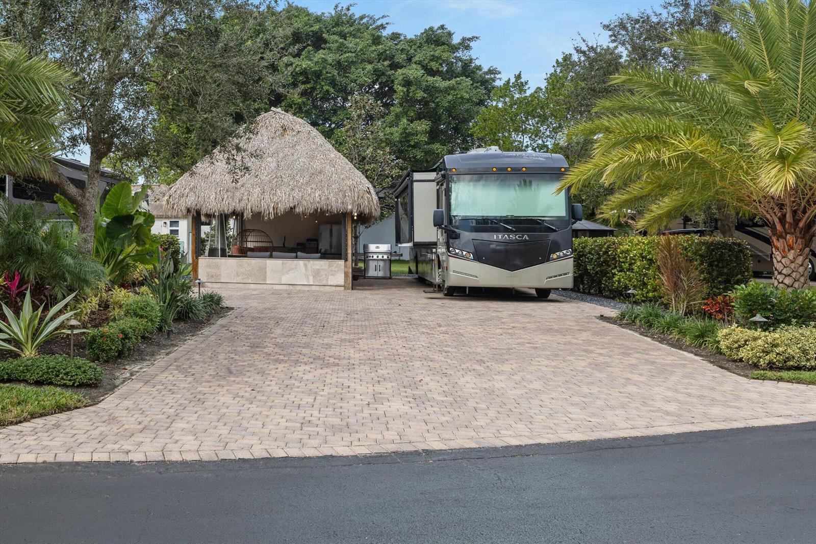 A paved driveway features a thatched-roof tiki hut and a parked motorhome — 204 N Cortez Drive # 204, Margate FL 33068, MARGATE, FL