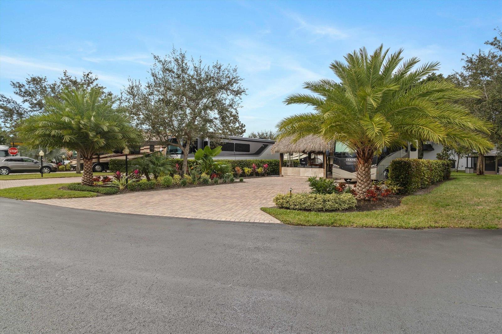 A paved driveway features two parked RVs, a tiki hut, and lush tropical landscaping — 204 N Cortez Drive # 204, Margate FL 33068, MARGATE, FL
