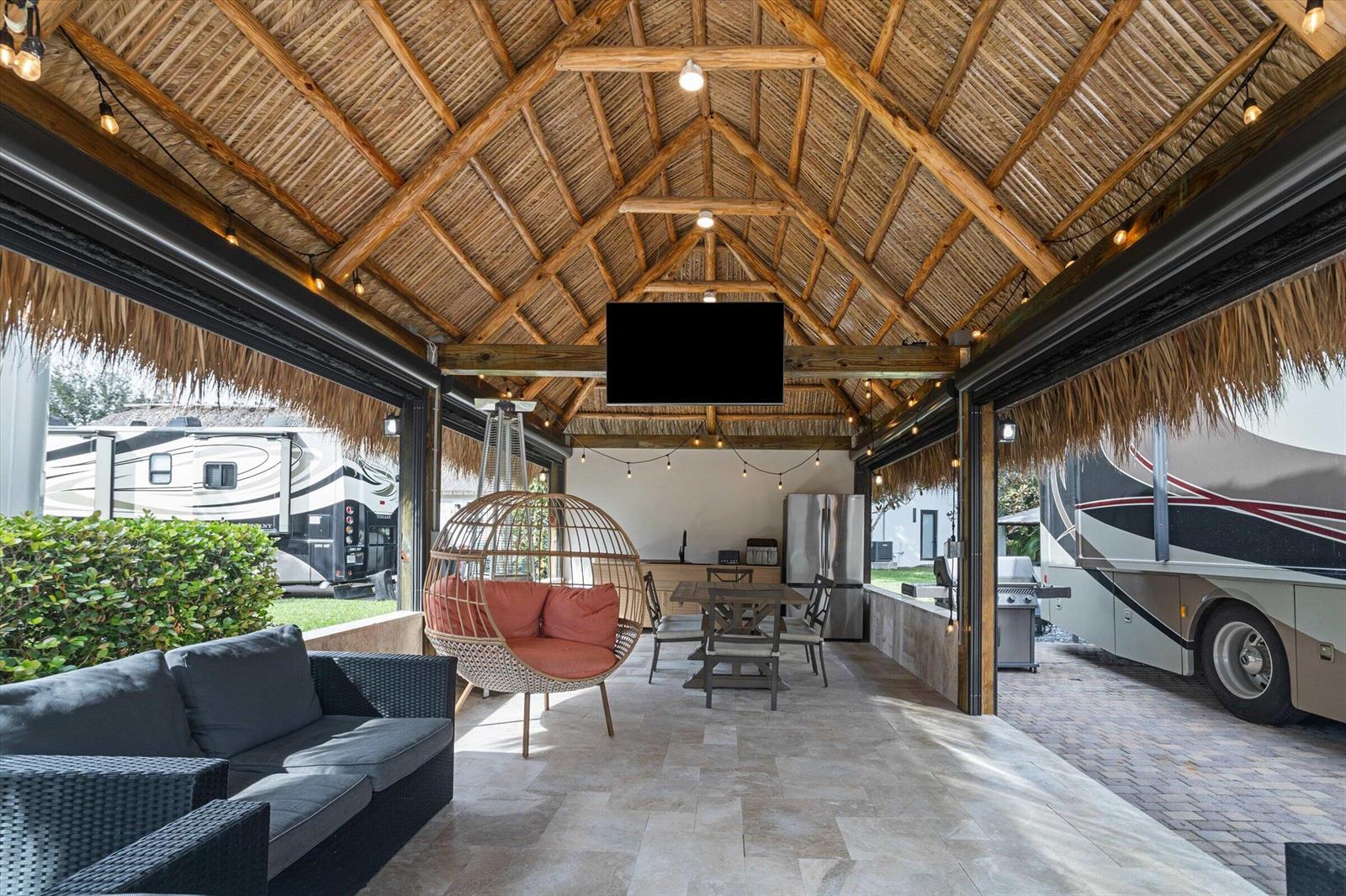 An open-air patio with a thatched roof, outdoor kitchen, dining area, and hanging chair — 204 N Cortez Drive # 204, Margate FL 33068, MARGATE, FL