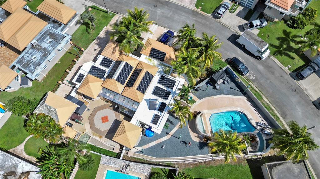 An aerial view of a house with solar panels, a swimming pool, and palm trees — G-6 LOMBARDIA STREET, NAGUABO, PR