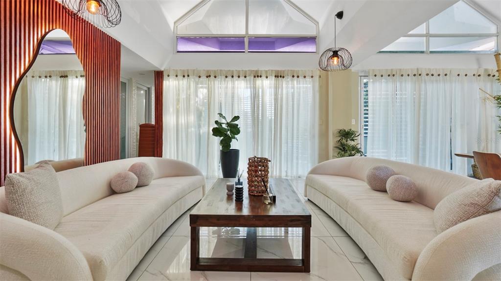 A living room features two curved white sofas, a wooden coffee table, and vaulted ceilings — G-6 LOMBARDIA STREET, NAGUABO, PR
