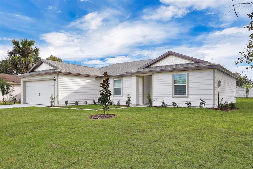 A single-story house with white horizontal siding, a two-car garage, and a green lawn — 2 RYMSHAW PLACE, PALM COAST, FL