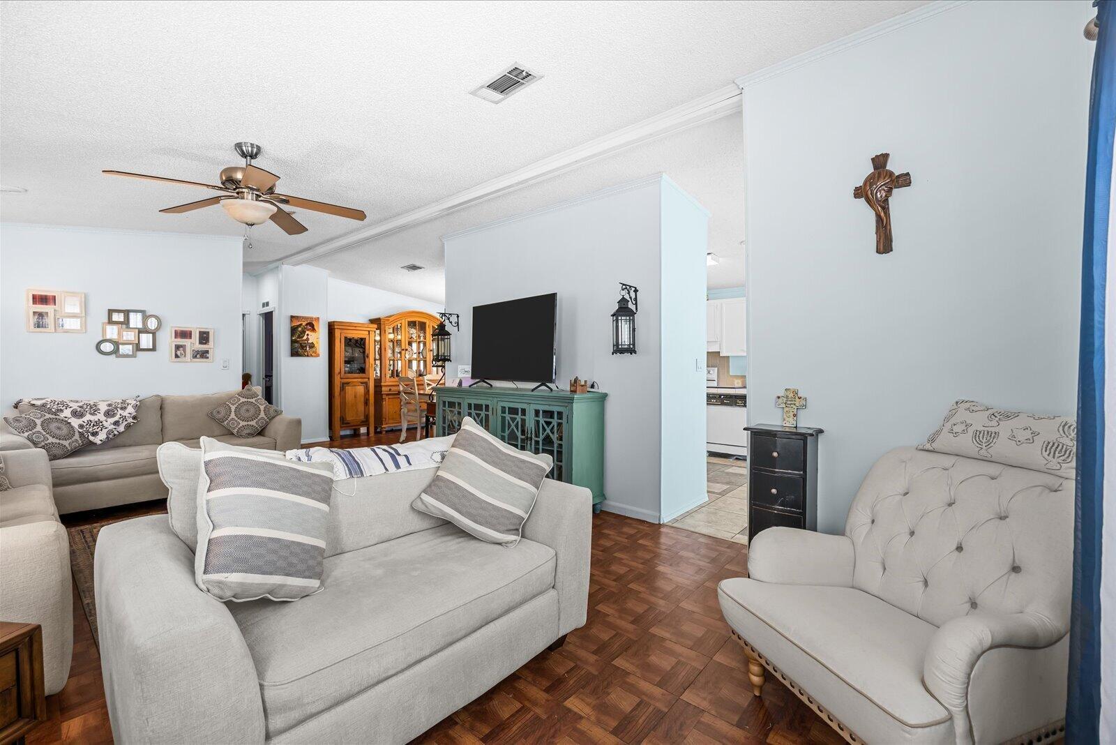 A living room features light blue walls, wood parquet flooring, and two light-colored sofas — 202 Sandy Bottom Place # 09, Fort Pierce FL 34982, FORT PIERCE, FL