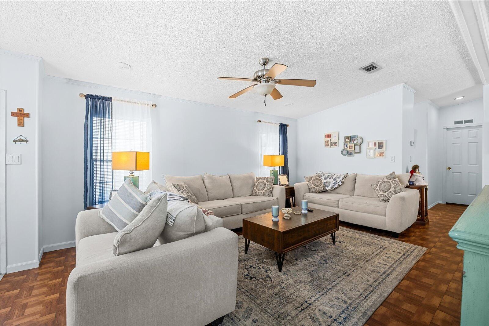 A living room features light-colored sofas, a wooden coffee table, and a patterned area rug — 202 Sandy Bottom Place # 09, Fort Pierce FL 34982, FORT PIERCE, FL