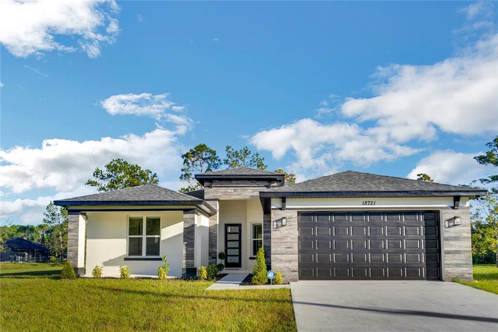 A single-story house with a white stucco facade, stone accents, and a two-car garage — 3724 CORONET AVENUE, ORLANDO, FL